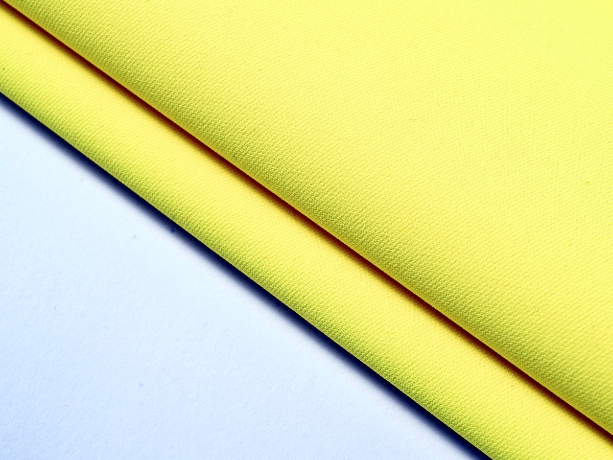 High visibility yellow fabric texture detail for workwear programs